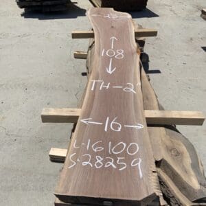 A large wooden slab with markings and measurements written in white.