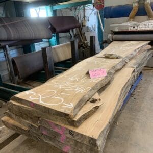 Stack of live-edge wood slabs in workshop