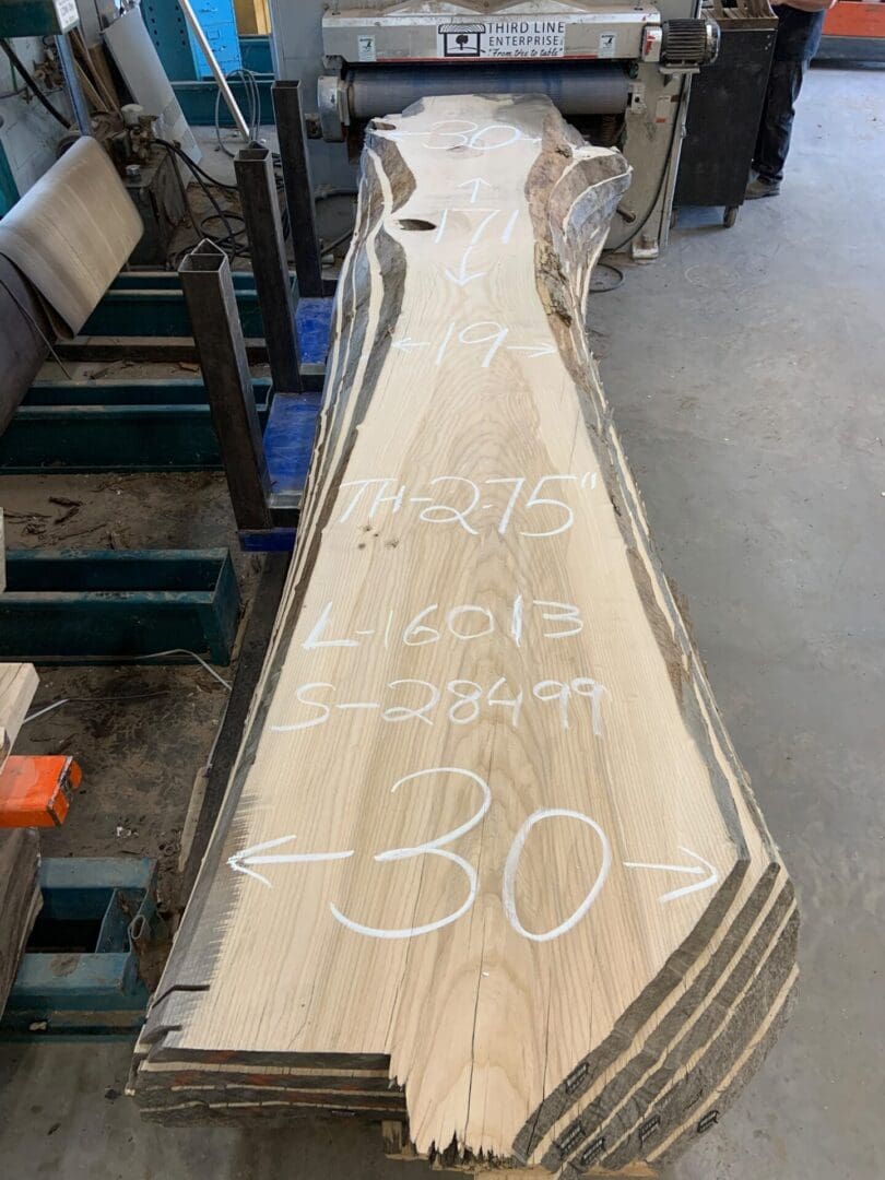 Long marked live-edge wood slab in workshop