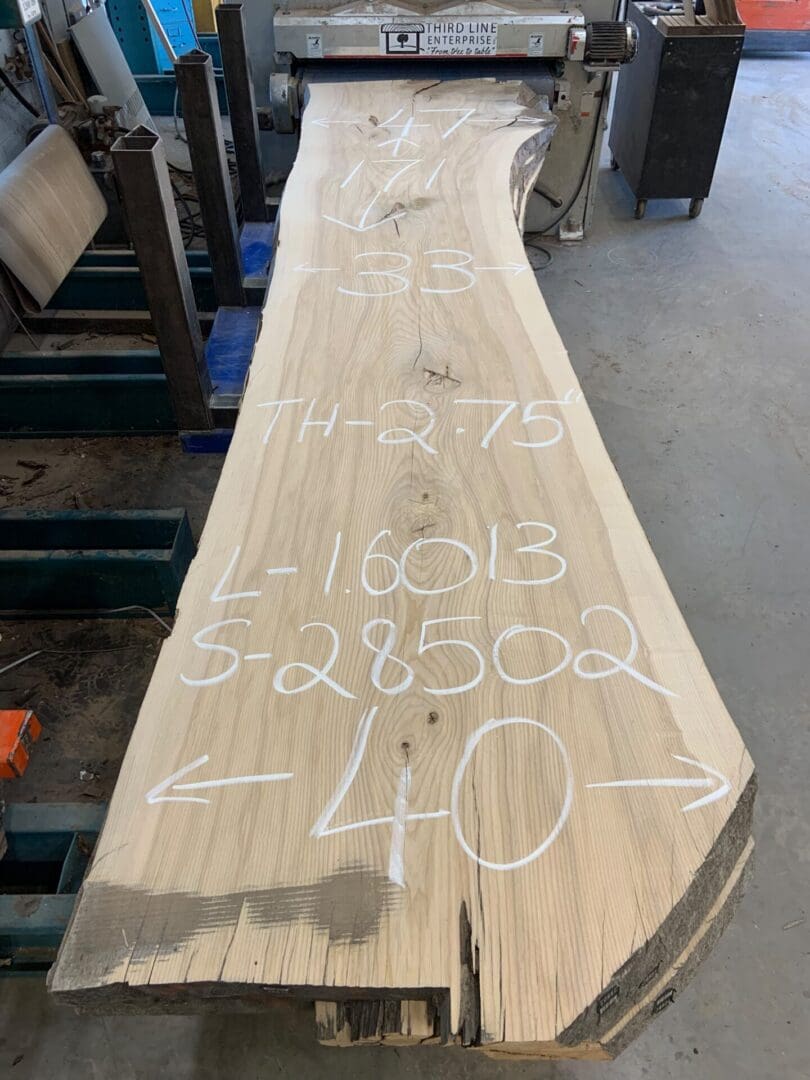 Live-edge wood slab with chalk measurements