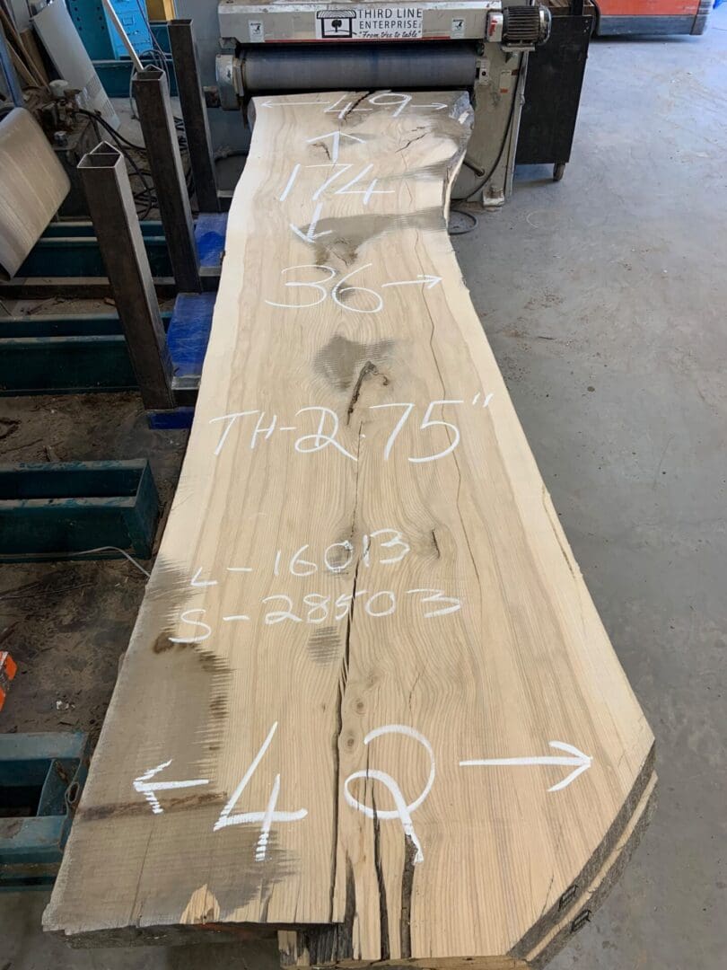 Long wooden slab with chalk measurements