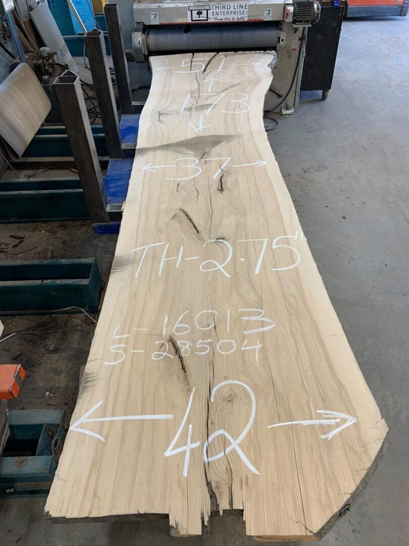 Chalk-marked live-edge wood slab in workshop
