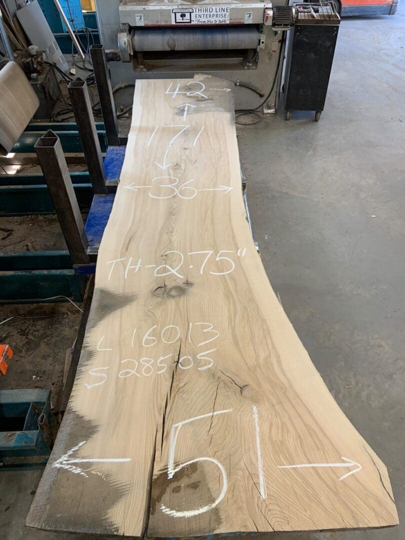 Live-edge wood slab with chalk measurements
